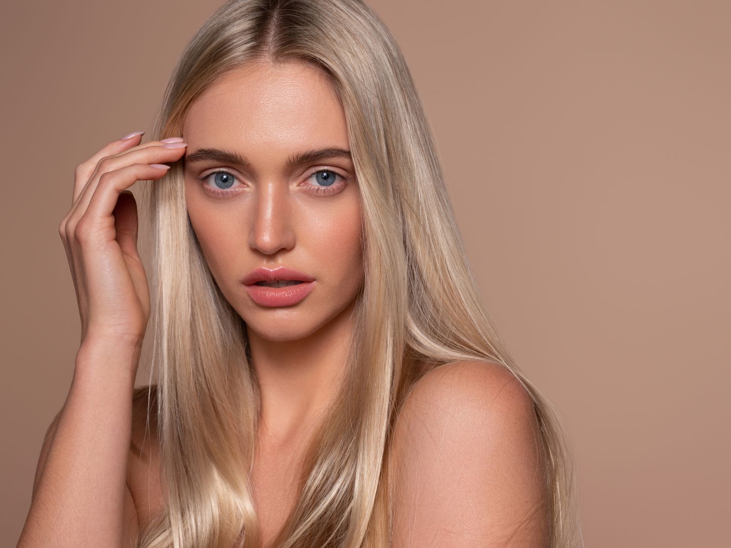 Model with long blonde hair and natural makeup.