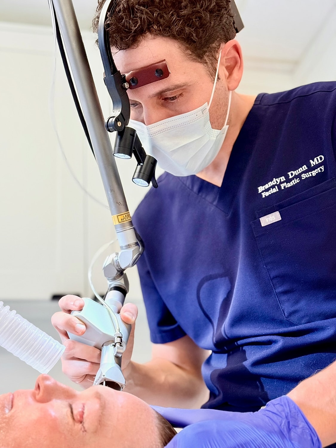 Doctor performing skin treatment on patient.