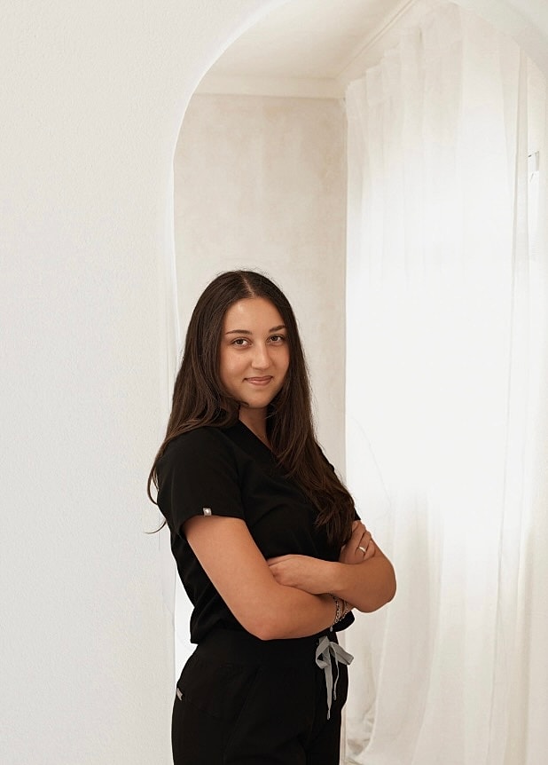 Person in black scrubs with arms crossed