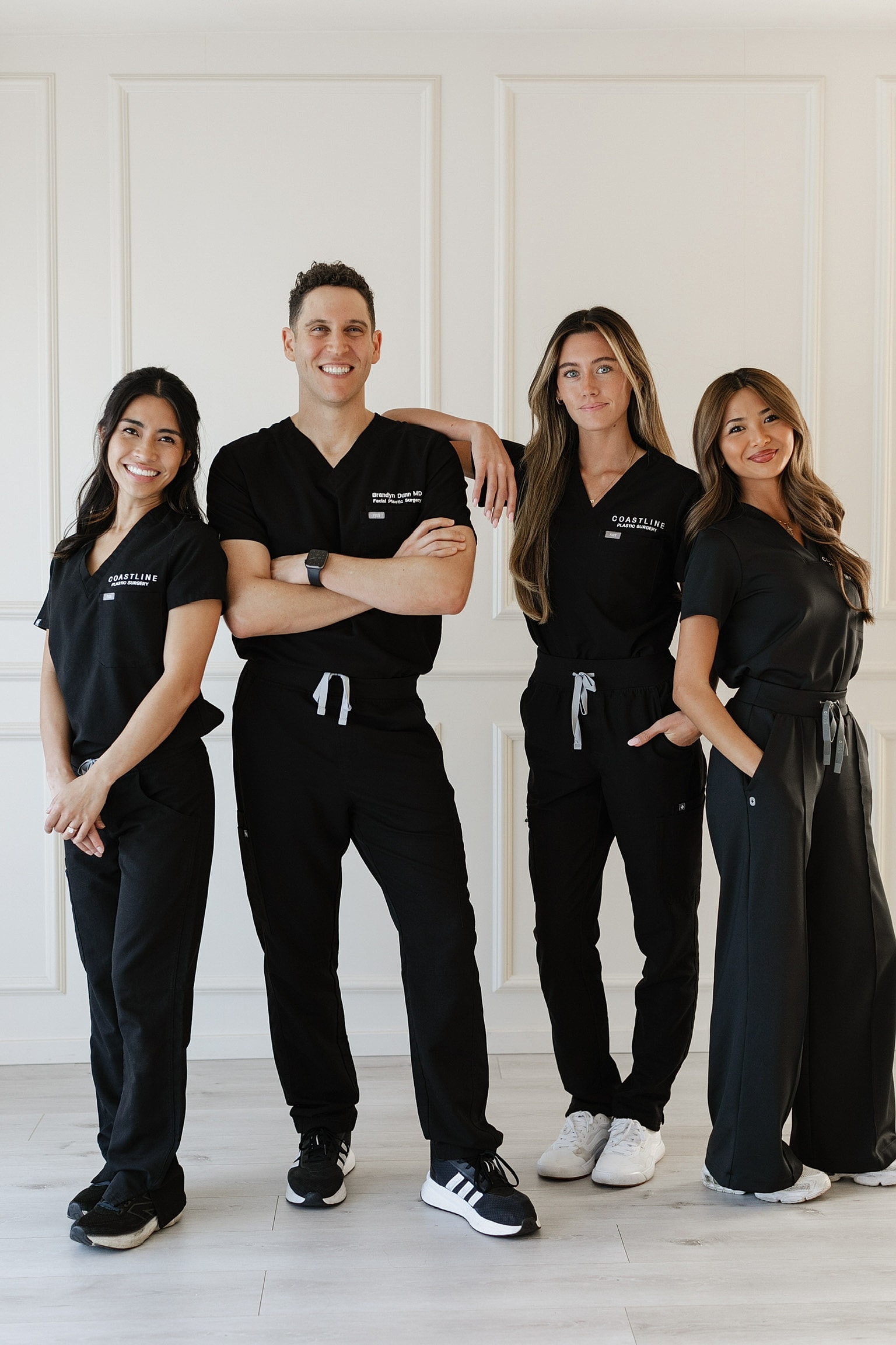 Medical professionals posing in stylish scrubs.