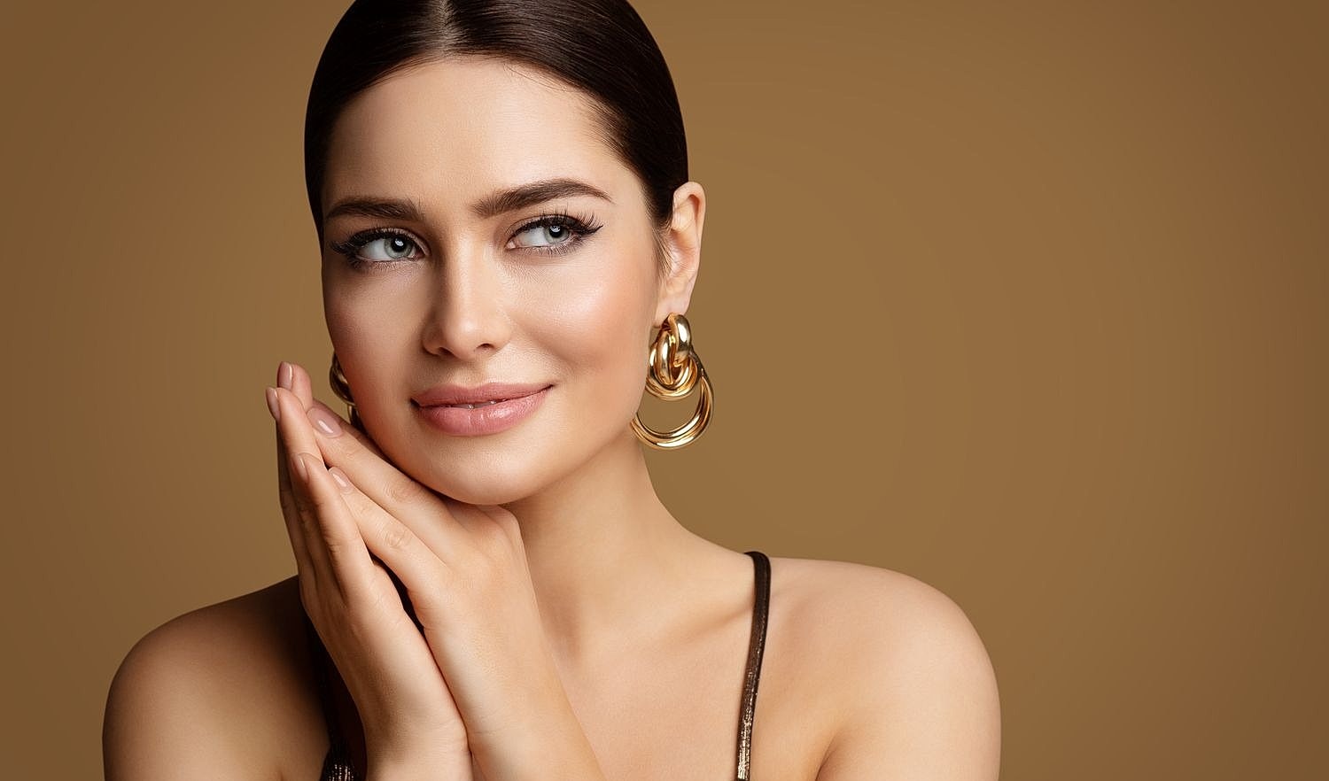 Woman with elegant earrings and soft smile.
