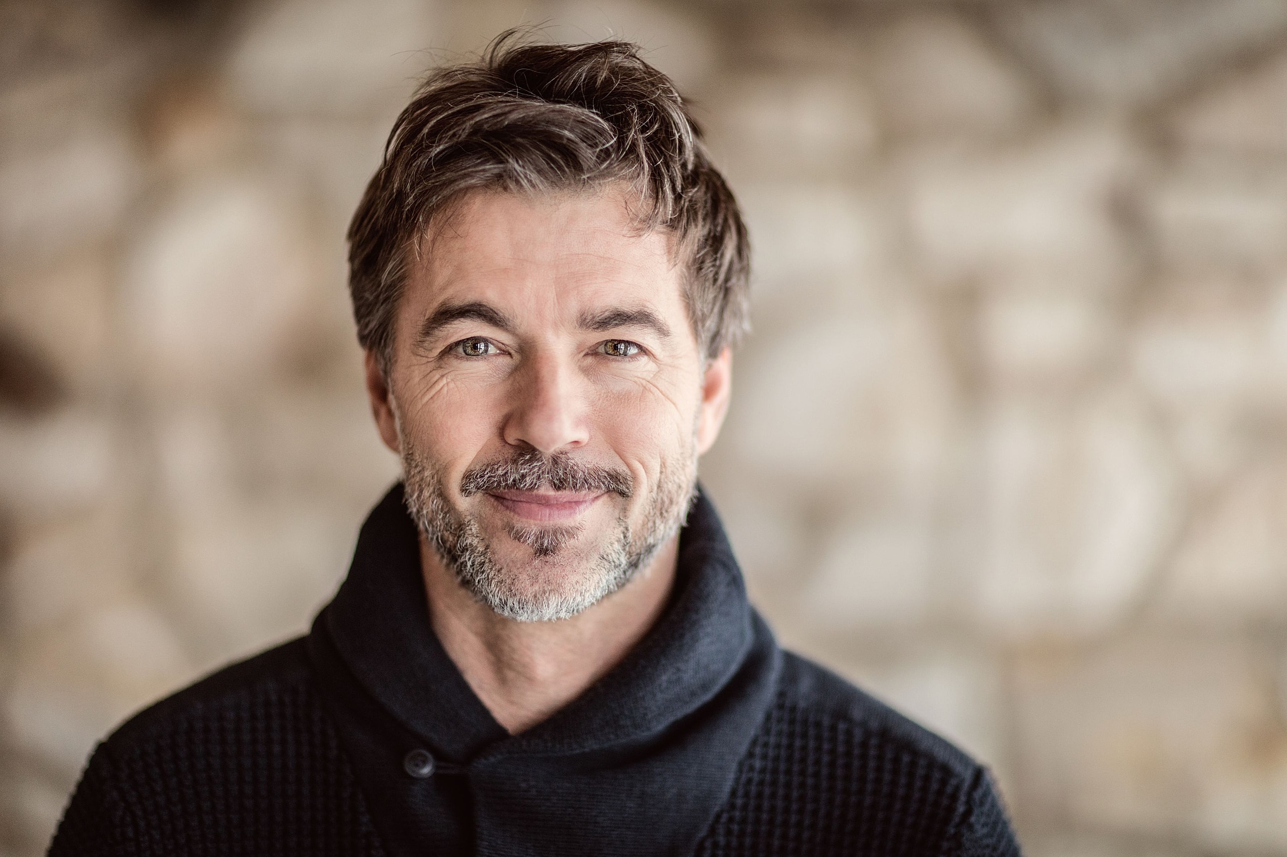 A middle-aged man with a well-defined jawline, illustrating the natural results of a male neck lift procedure.